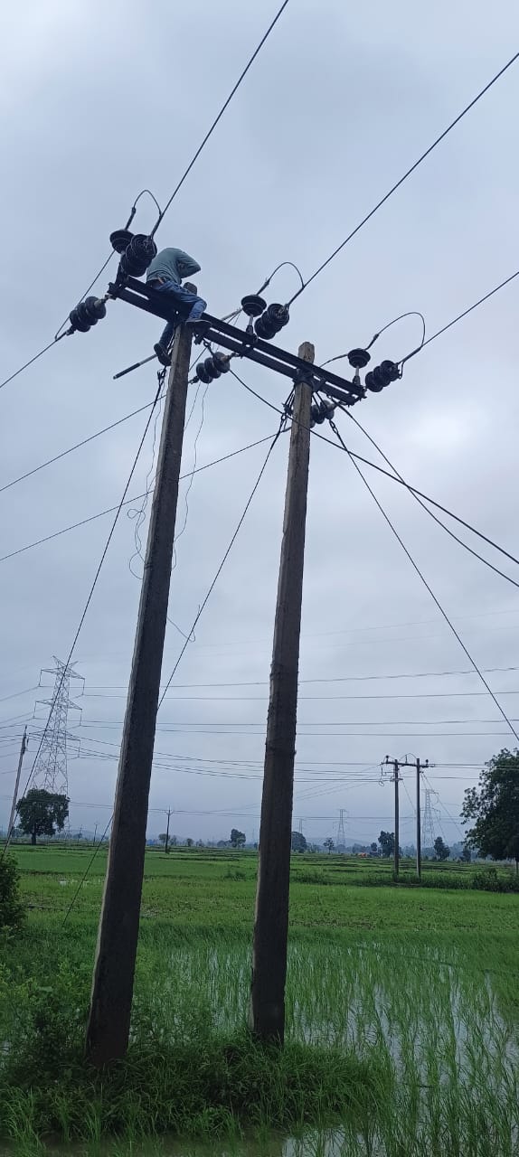 भारी बारिश के दौरान भी बिजली सुचारू बनाने की जद्दोजहद करते बिजली कर्मचारी।