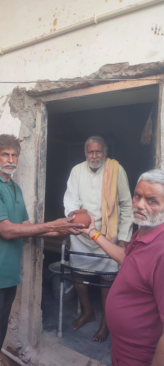 पांव से लाचार, मगर हौसला बुलंद—पक्षियों की प्यास बुझाने में जुटे रतन लाल जायसवाल।घुटनों की गंभीर बीमारी के बावजूद नगर में जगह-जगह जलपात्र टांगकर दे रहे मानवीय संवेदना का संदेश।